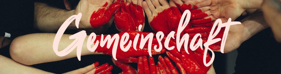 Rotes Herz mit Händen und der Aufschrift "Gemeinschaft"